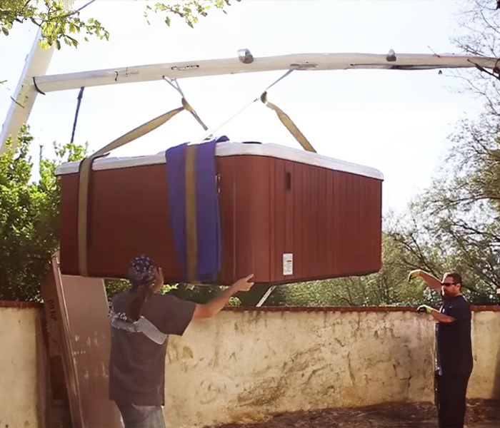 installers lowering a hot tub woth a crane